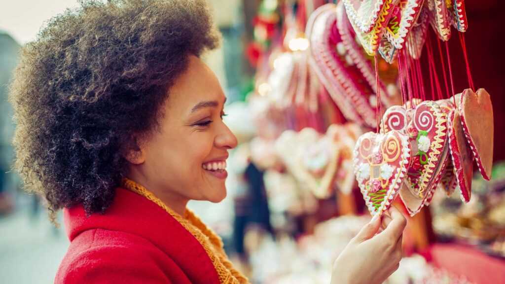 Portrait of beautiful woman buying gingerbread hearts in gift shop