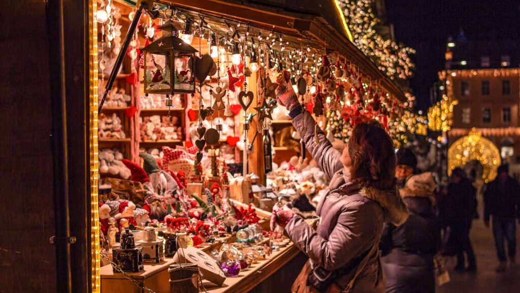 Women shopping at christmas market stall ornaments