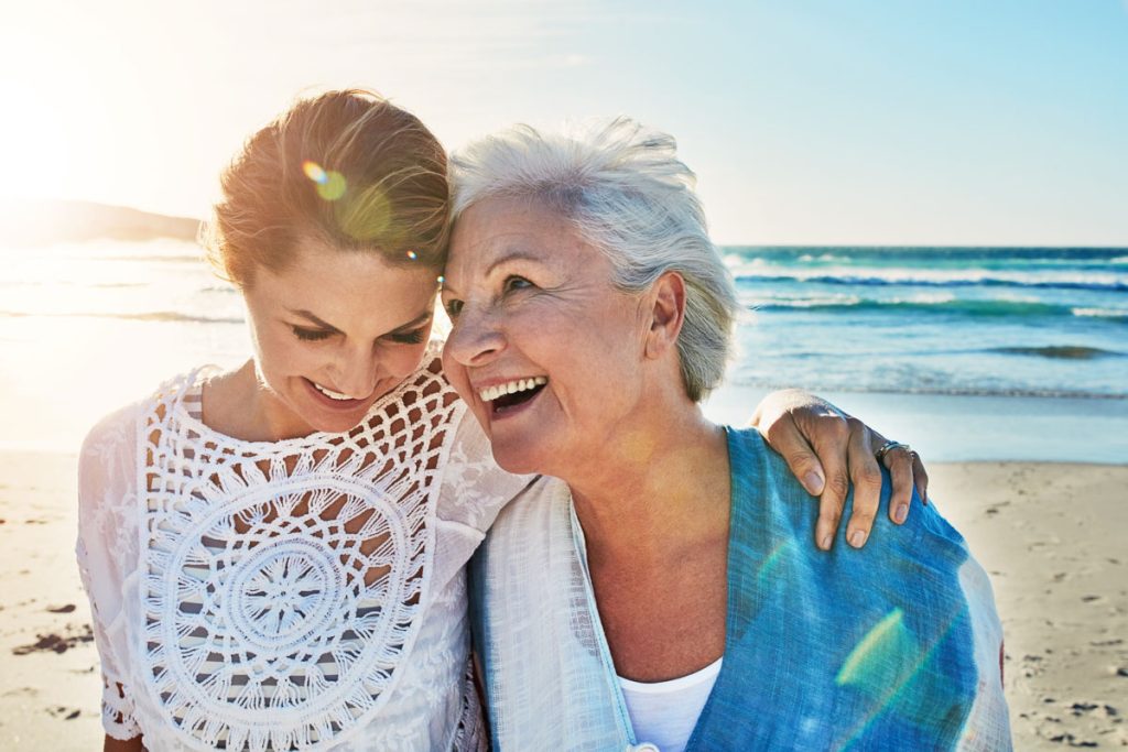 a senior woman and her adult daughter spending a day at the beach