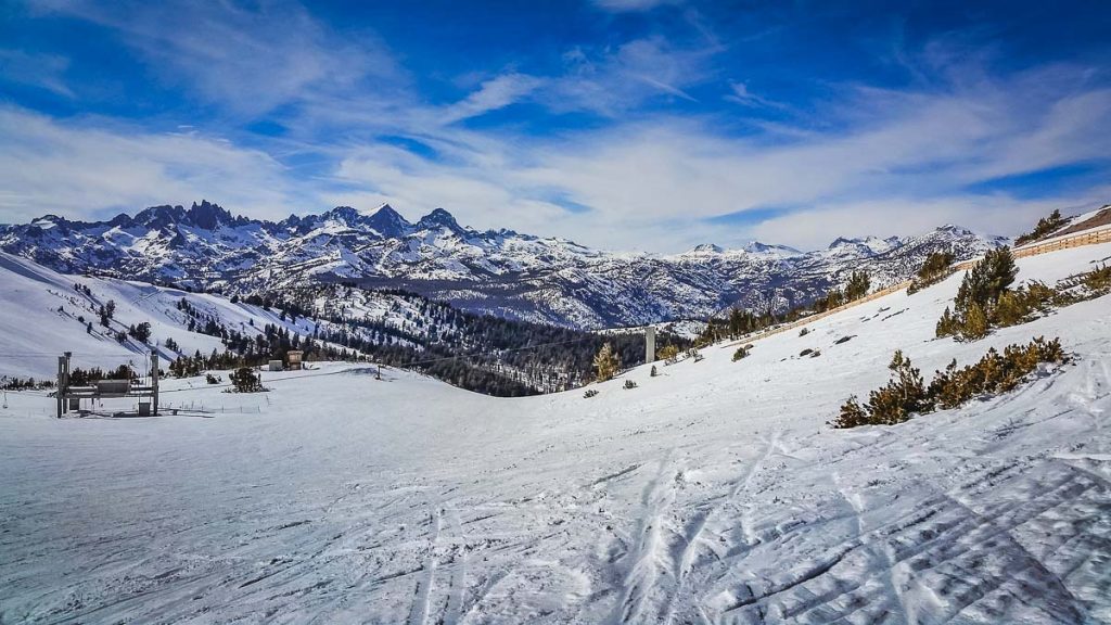 Panoramic view of steep ski trail with snow-covered Sierra Nevada Mountain Range in the background, Mammoth Mountain, Mammoth Lakes, California