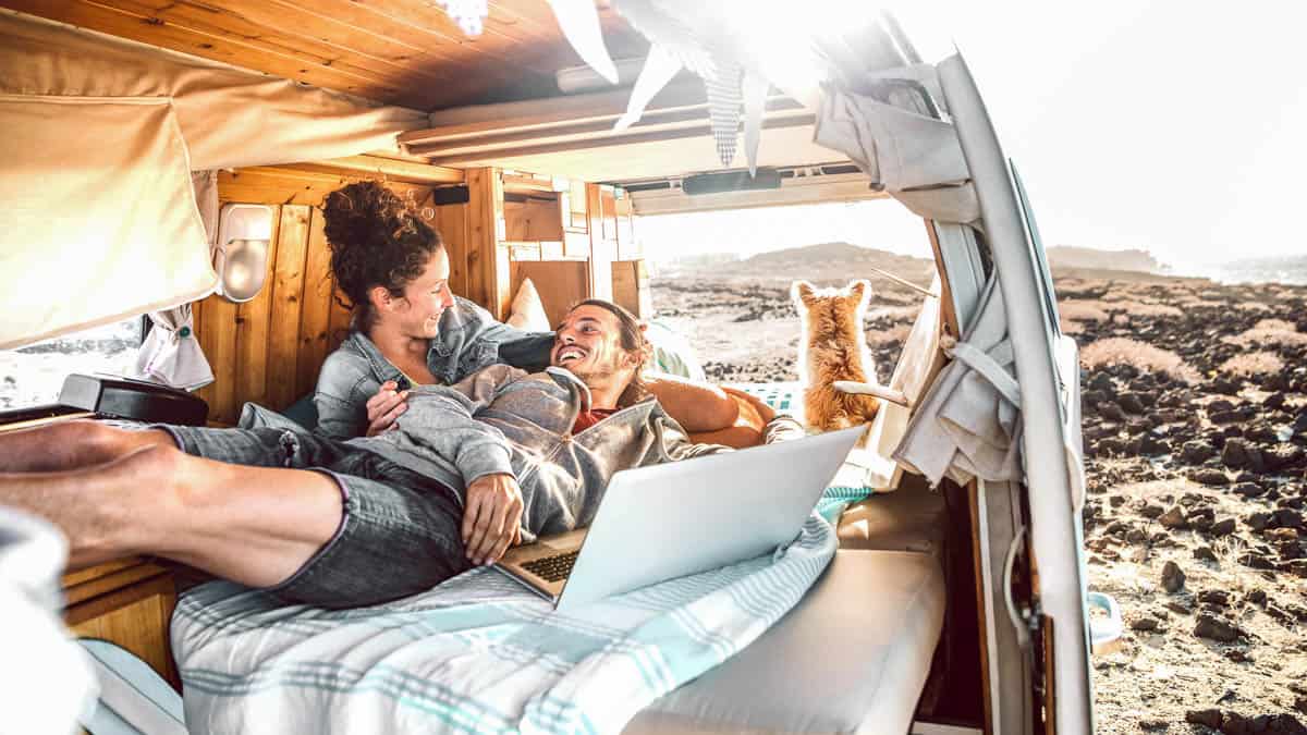 Digital nomad, Hipster couple with dog traveling together on retro mini van