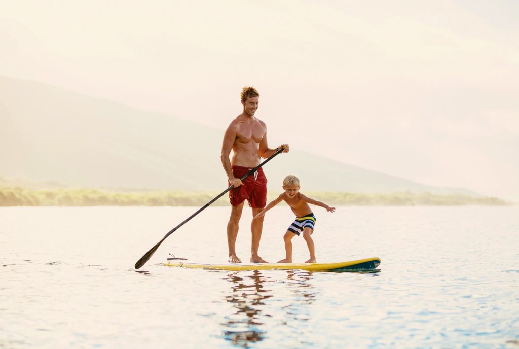 Father and Son Stand Up Paddling at Sunrise