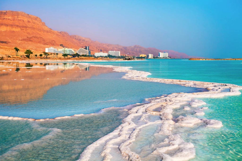 Israel, Ein Bokek, Dead Sea salt shoreline with turquoise water and desert mountains