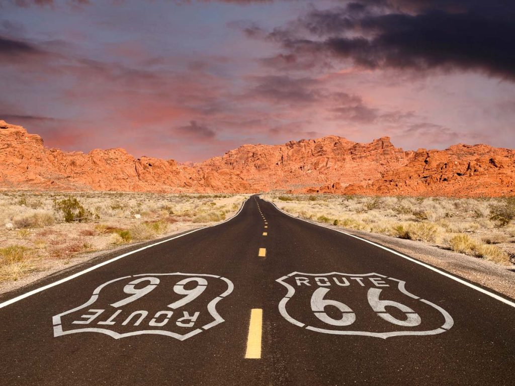 Route 66 Pavement Sign with Red Rock Mountain Sunset road trip
