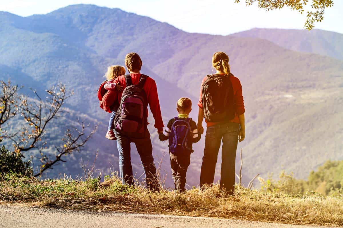 family with two small kids hiking in mountains