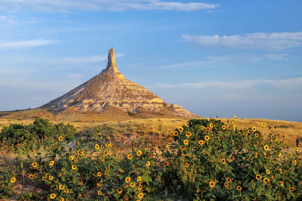 Chimney Rock National Historic Site with sunflowers, western Nebraska, USA. The peak of Chimney Rock is 1289 meters above sea level.
