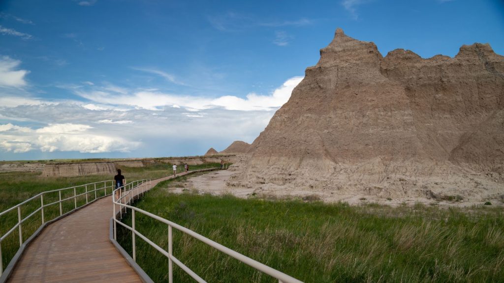 Tourists hike along the boardwalk trail of the Notch and Window trail in Badlands National Park