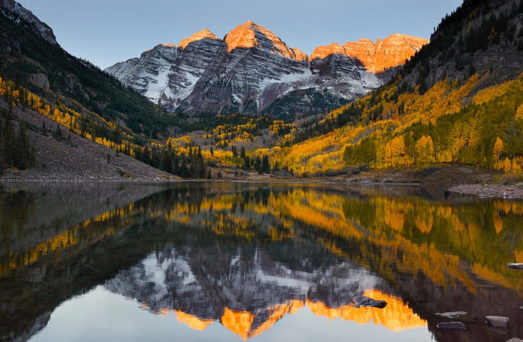 Beautiful sunrise touches Maroon bells peak at Maroon lake, Aspen, Colorado. Fall color of Aspen and reflection of Maroon Bells