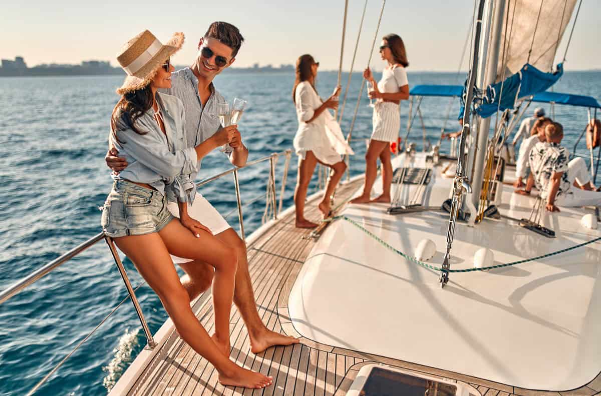 Group of friends relaxing on luxury yacht. Having fun together while sailing in the sea. Traveling and yachting concept.