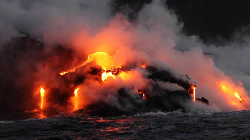 Lava running in the ocean from volcanic lava eruption on Big Island Hawaii. Seen from lava boat tour. Lava from Kilauea volcano by Hawaii volcanoes national park, USA.
