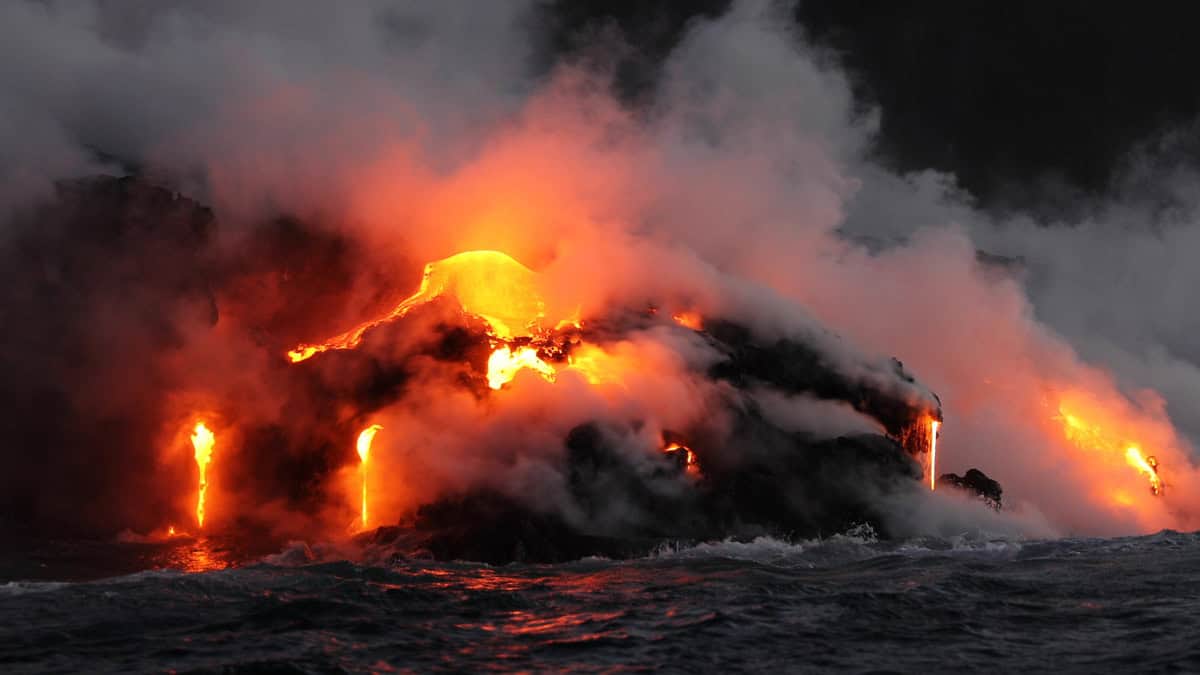 Lava running in the ocean from volcanic lava eruption on Big Island Hawaii. Seen from lava boat tour. Lava from Kilauea volcano by Hawaii volcanoes national park, USA.