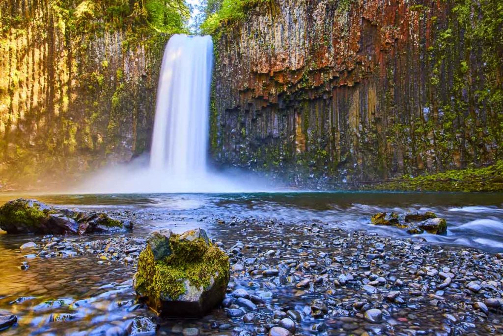 Oregon, Abiqua Falls, framed by moss-covered basalt columns and bathed in soft sunlight