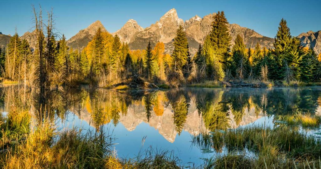 Teton mountains reflect on the Snake river at Schwabacher Landing in Grand Teton National Park, Wyoming