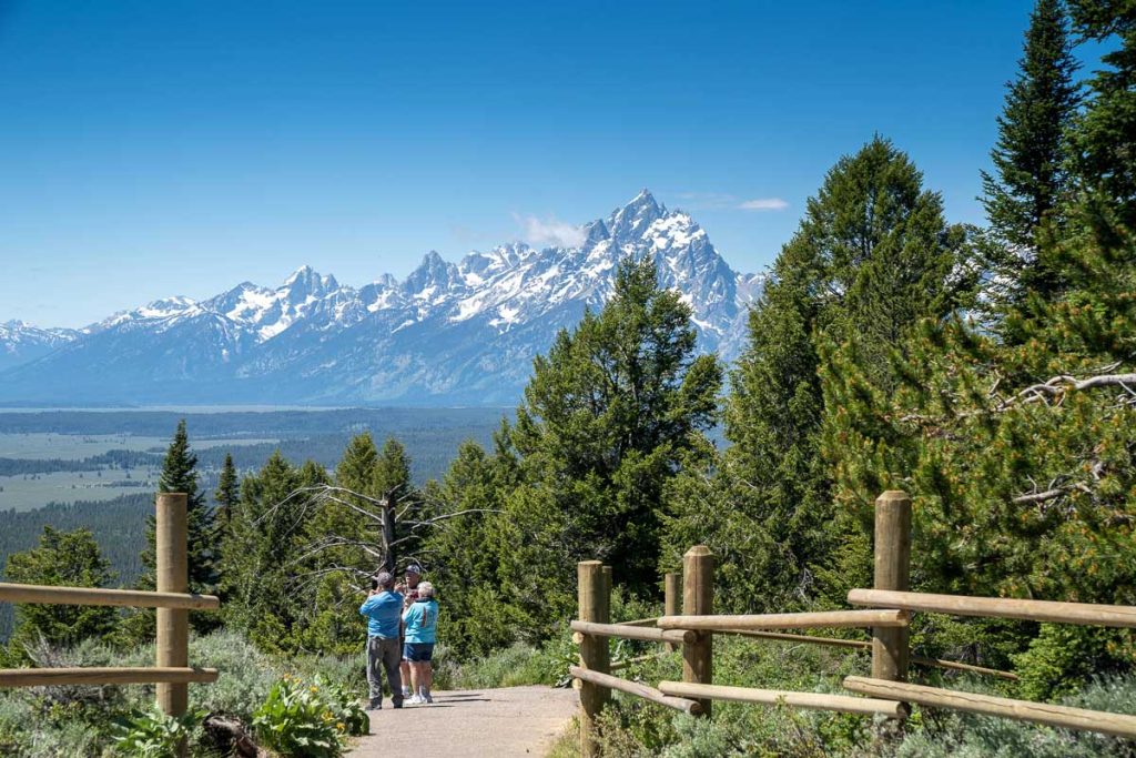Wyoming, USA Senior citizen tourists enjoy taking photos on top of Signal Mountain Overlook in Grand Teton National Park