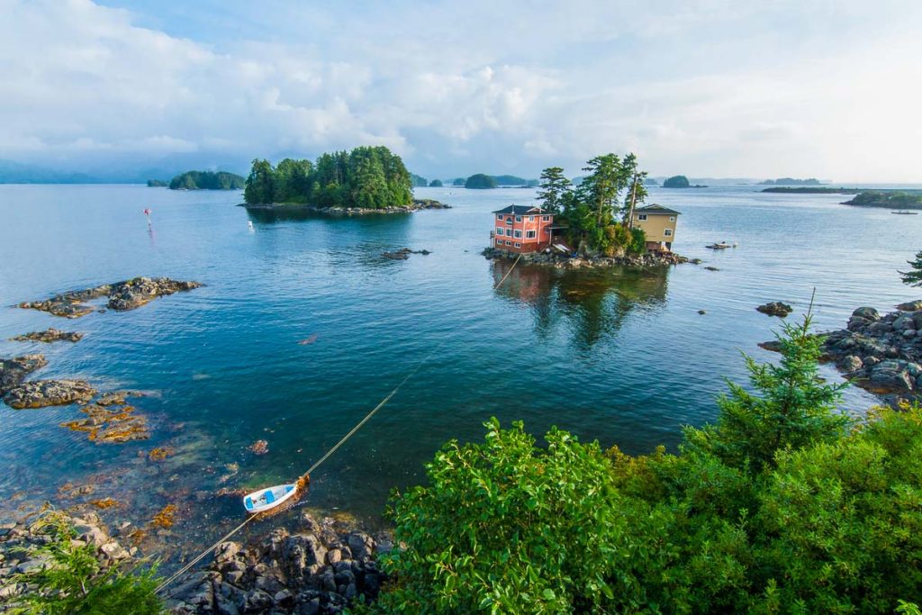 Beautiful calm summer, seascape with boat and houses on tiny forested islands in Sitka Sound on Baranof Island, Alaska