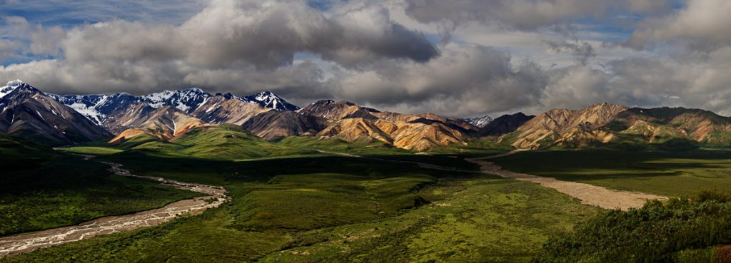 Denali National Park, Alaska, broad tundra valley with winding river beneath the Alaska Range and dramatic cloud cover