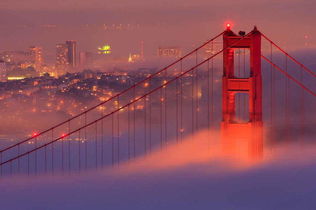 Golden Gate Bridge emerging through coastal fog at dusk, San Francisco, California
