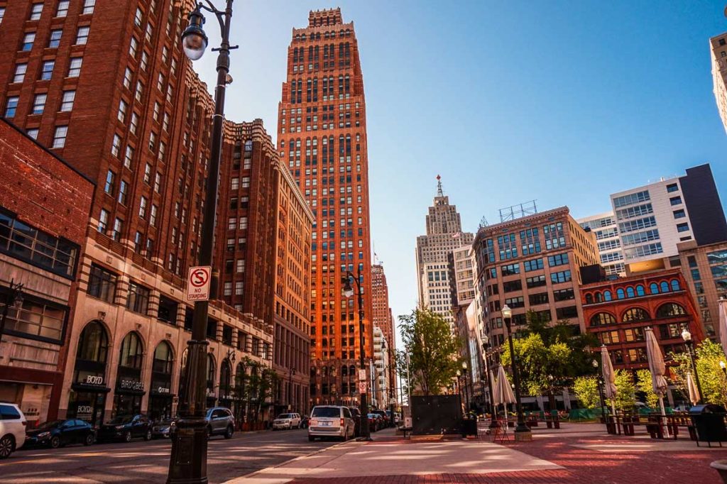 Michigan, Detroit, downtown street scene lined with historic brick skyscrapers and modern office buildings under a clear daytime sky