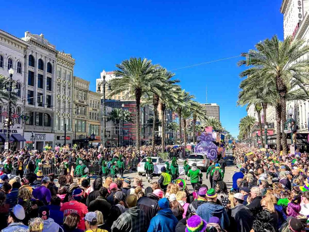 Crowd of tourists and locals along city streets. Mardi Gras is the biggest celebration the city of New Orleans hosts every year.