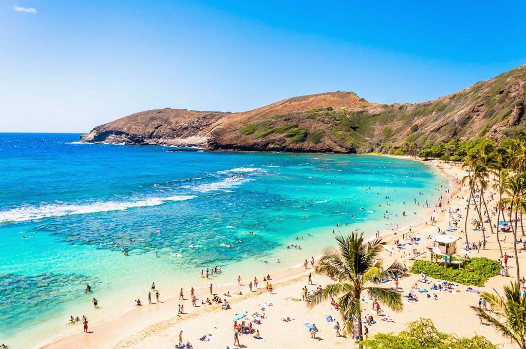 Oahu, Hawaii coastline with turquoise waters and beachgoers enjoying a sunny day along the shore