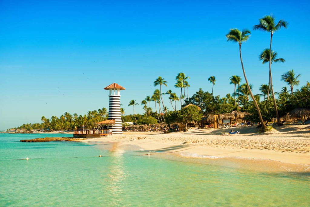 Paradise tropical island in Dominican Republic. White sand, blue sea, clear sky and lighthouse on shore