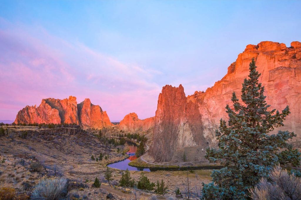 Smith Rock State Park, Oregon, USA. Sunrise light illuminating red rock cliffs above the Crooked River