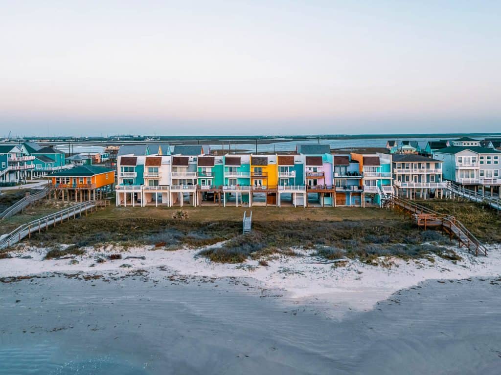 Texas, colorful beachfront houses on stilts lines the shore of Surfside Beach